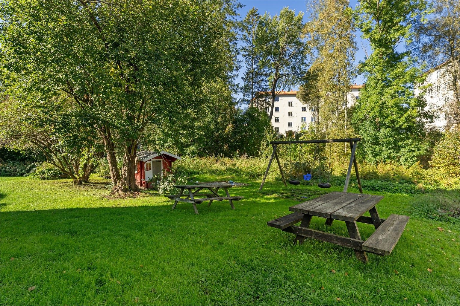 Store, grønne plener med sittegrupper inviterer til sosialt samvær og lek.