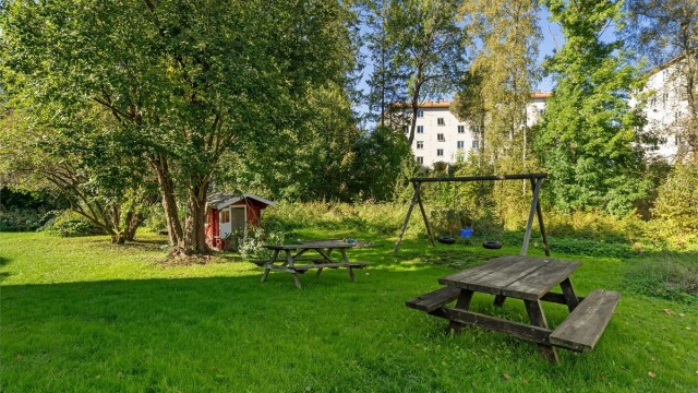 Store, grønne plener med sittegrupper inviterer til sosialt samvær og lek.