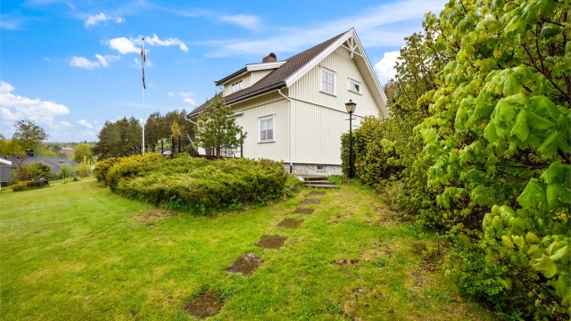 Den svakt skrånende tomten på over 1,5 mål er svært pent opparbeidet og er usjenert.