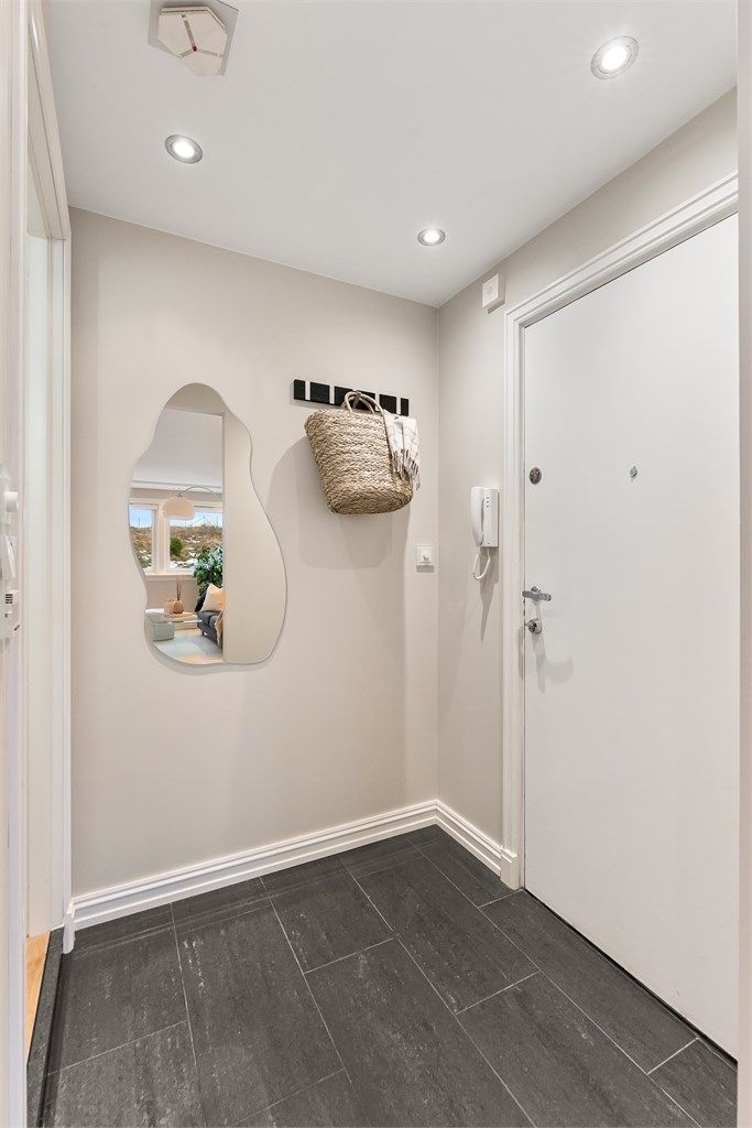 Entréen har flislagt gulv, gulvvarme og porttelefon. Herfra er det inngang til badet og stuen.