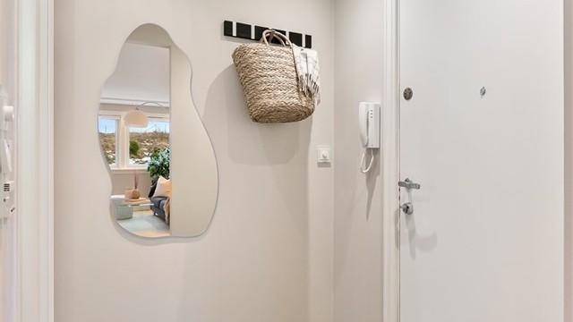 Entréen har flislagt gulv, gulvvarme og porttelefon. Herfra er det inngang til badet og stuen.