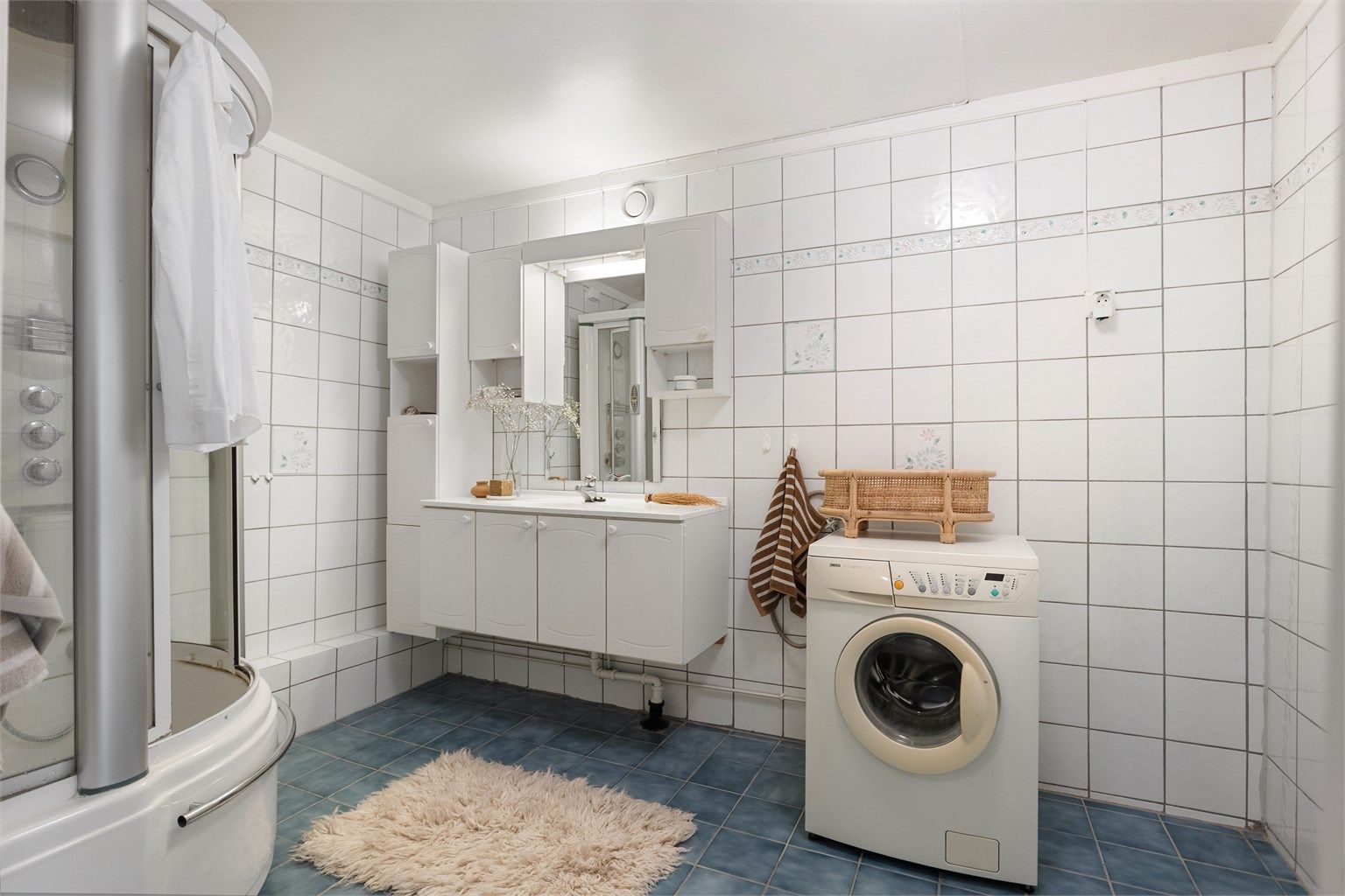 Badet har flislagte vegger og mekanisk avtrekk.