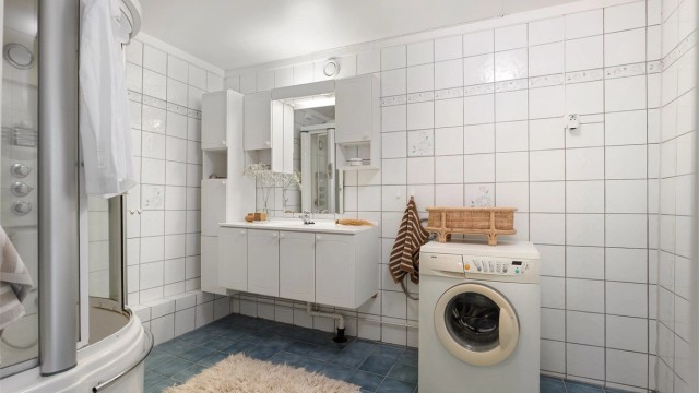 Badet har flislagte vegger og mekanisk avtrekk.