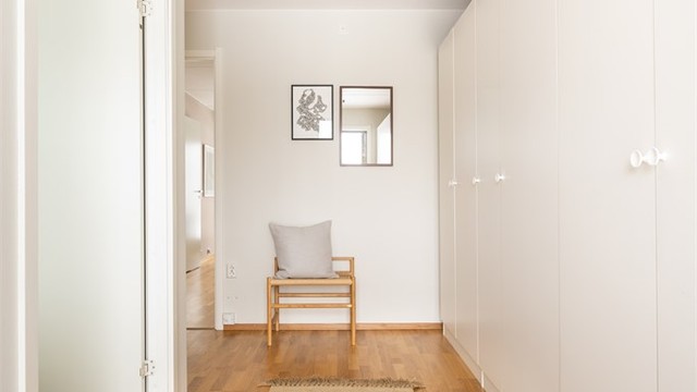 Romslig og fin gang med god oppbevaring i skaprekken på hele veggen.