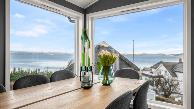 Lys og romslig spiseplass med store vindusflater som slipper inn rikelig med dagslys og gir flott utsyn mot fjorden.