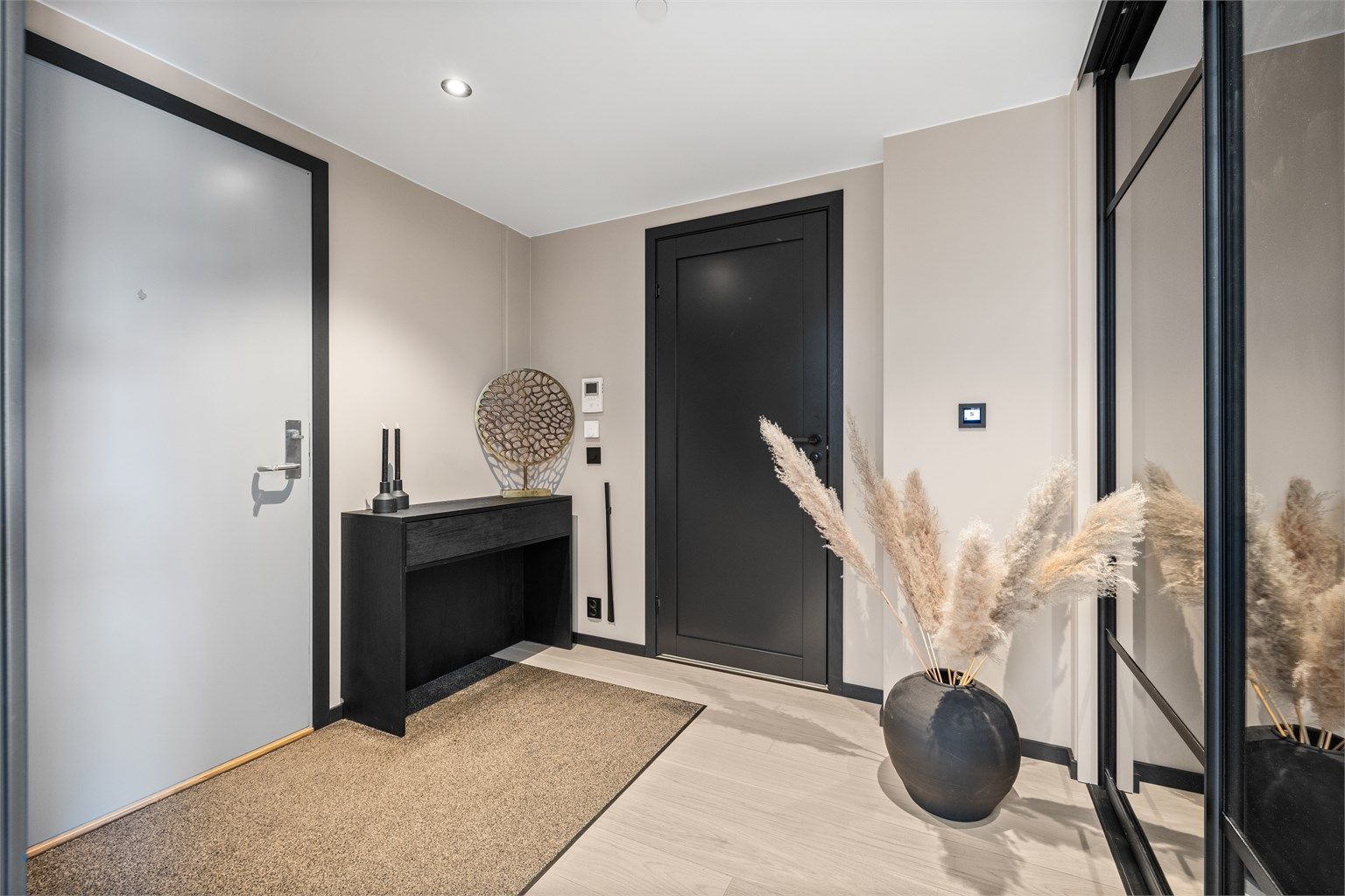 Romslig og pen entré med skyvedørsgarderobe. Dørcalling anlegg og vannbåren varme i gulv.