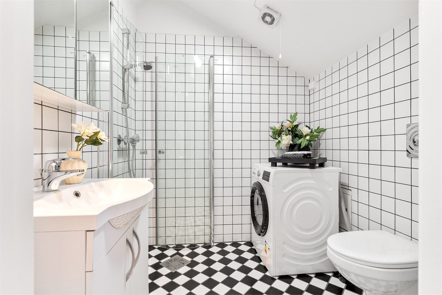 Badet er innredet med dusjhjørne, vegghengt toalett, servant med underskap, speilskap med belysning samt opplegg for vaskemaskin. Foto: Trond Walsø / Walso Work