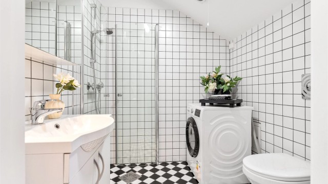 Badet er innredet med dusjhjørne, vegghengt toalett, servant med underskap, speilskap med belysning samt opplegg for vaskemaskin. Foto: Trond Walsø / Walso Work
