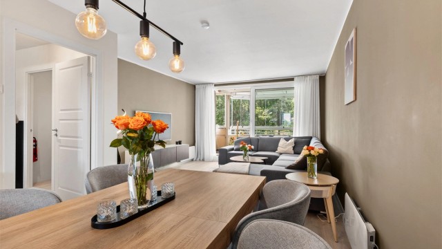 Den romslige stuen har naturlige soner for både spiseplass og sofagruppe – perfekt for både hverdag og hyggelige sammenkomster.