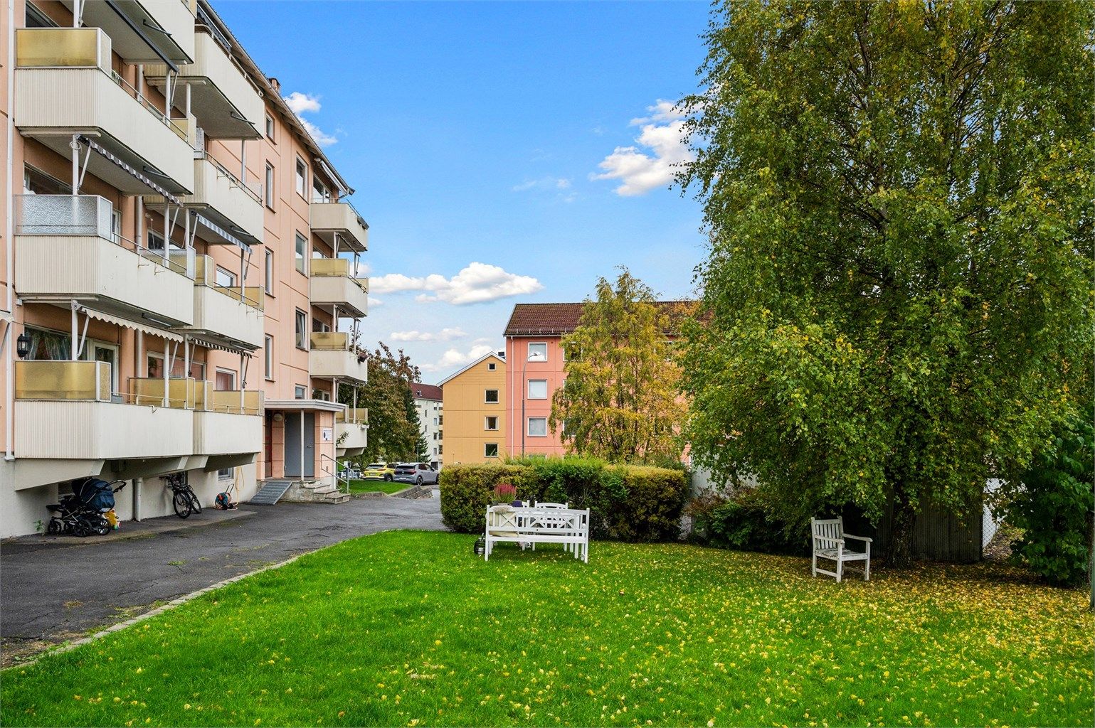 På forsiden av blokken er det satt ut sittegruppe som innbyr til grilling, mens barna sparkesykler eller hopper paradis