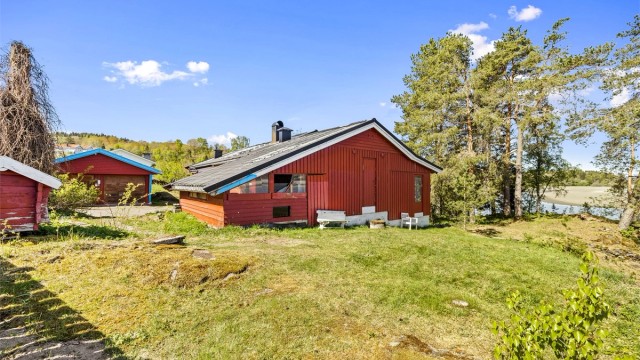 Den store tomten er delvis naturtomt og delvis opparbeidet med plen og beplantning.