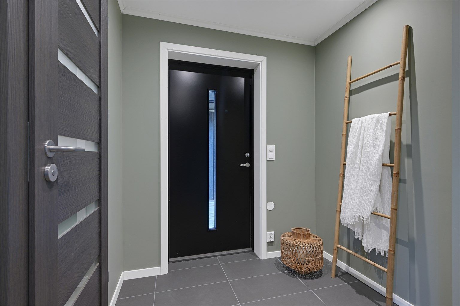 Entré med flislagt gulv med varmekabler og plass til yttertøy og sko.