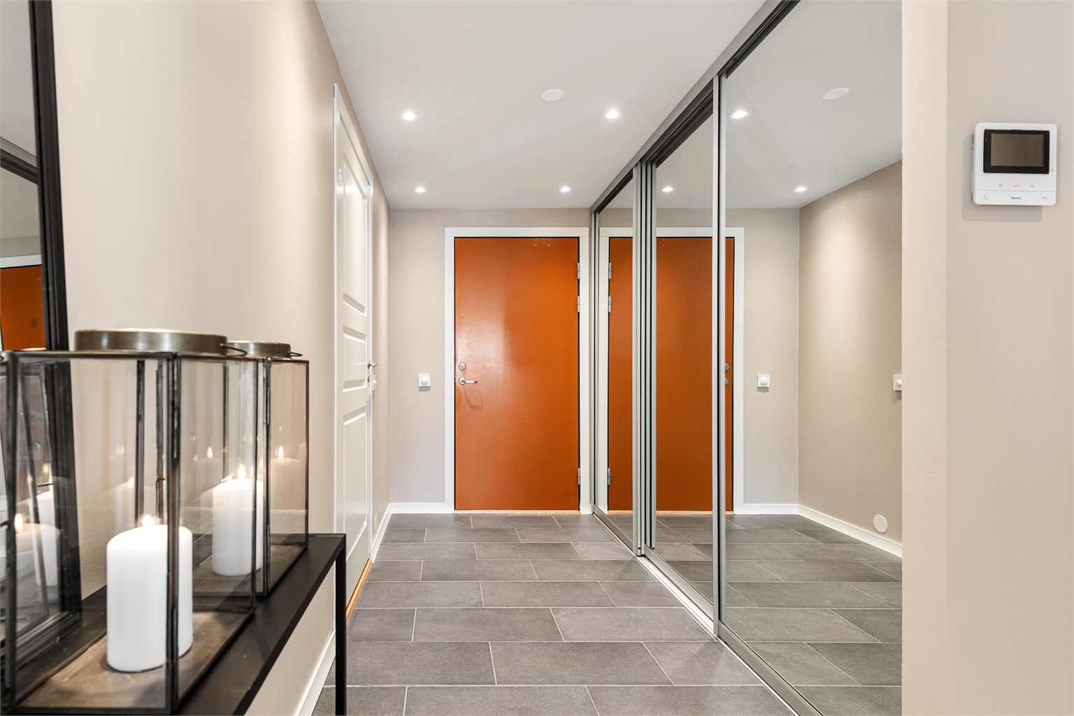 Entréen har flislagt gulv med varme og en romslig skyvedørsgarderobe med speilfronter