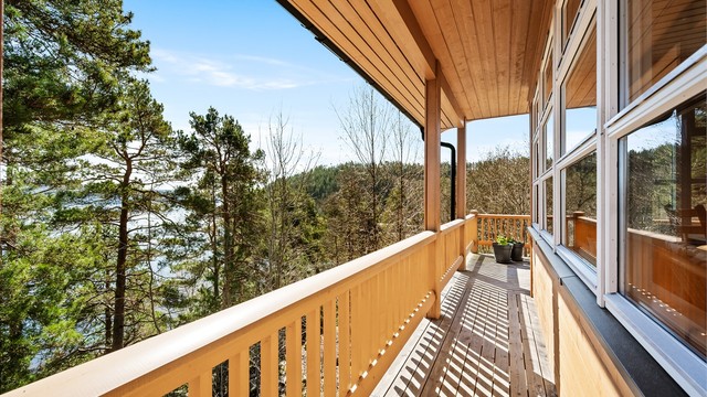 Verandaen/terrassen strekker seg langs store deler av hytta og binder rommene sammen utvendig.
