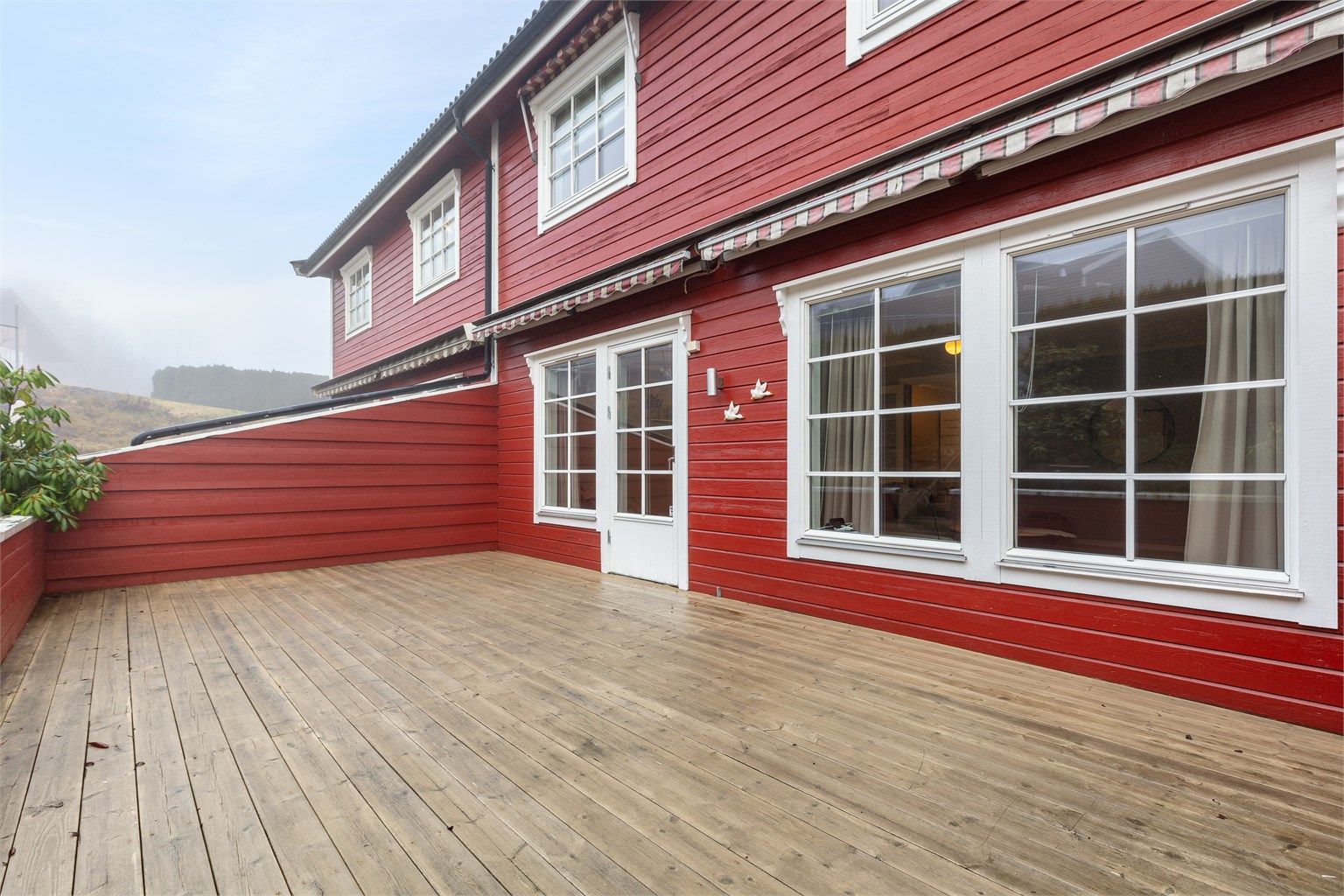 Her er det god plass til både sittegruppe og grill. 2 manuelle markiser over vinduene.