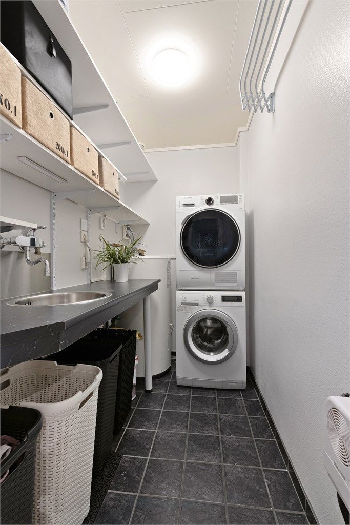 Separat vaskerom med flislagt gulv med gulvvarme, opplegg for vaskemaskin og god lagringsplass. Her er også boligens varmtvannsbereder.