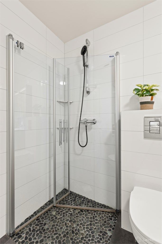 Praktisk dusjhjørne med innfellbare glassdører.