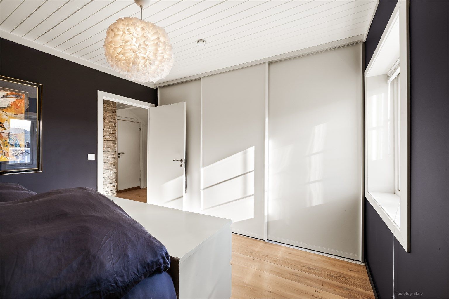 Hovedsoverommet i 2. etasje har en plassbygget skyvedørsgarderobe i hvit og glatt utførelse.