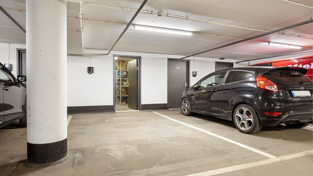 Parkeringsplass tilhørende leiligheten, med praktisk bod i bakkant. Det er klargjort for el-bil lader men selve ladeboksen må bestilles via sameiet
