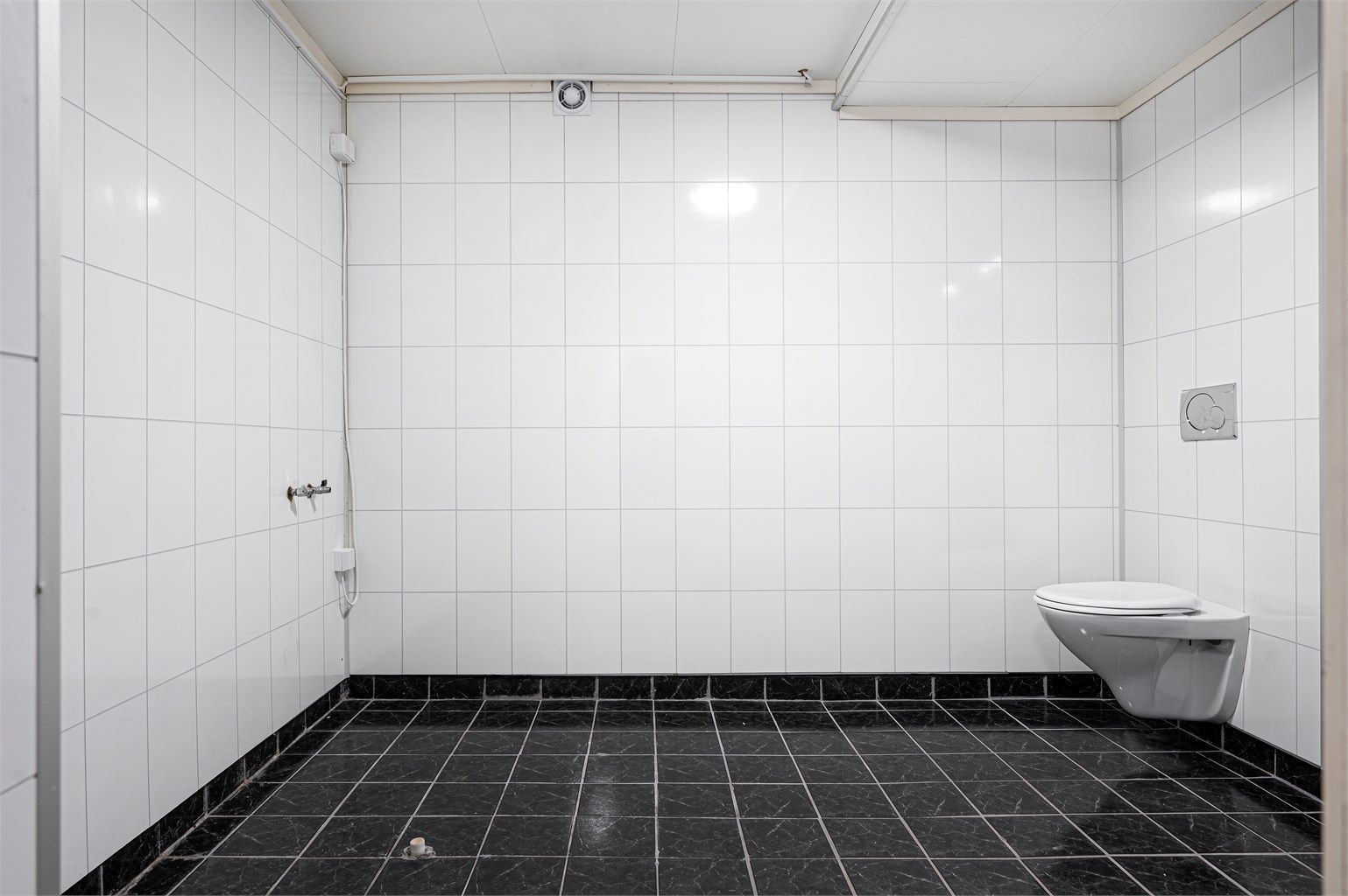 Badet har vegghengt toalett og er klargjort med opplegg for badekar.