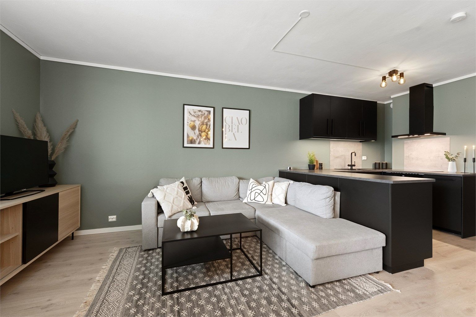 Stue og kjøkken i åpen løsning. Kjøkkenet har praktisk halvøy mot stuedel.