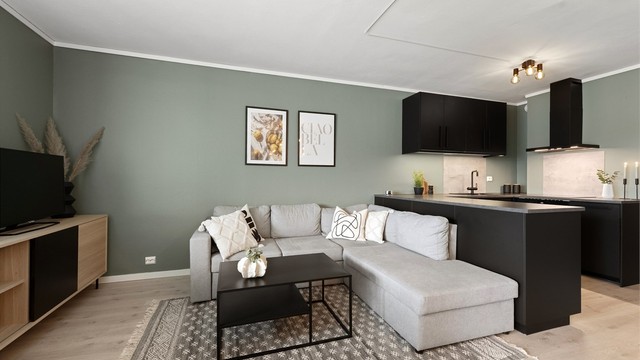 Stue og kjøkken i åpen løsning. Kjøkkenet har praktisk halvøy mot stuedel.