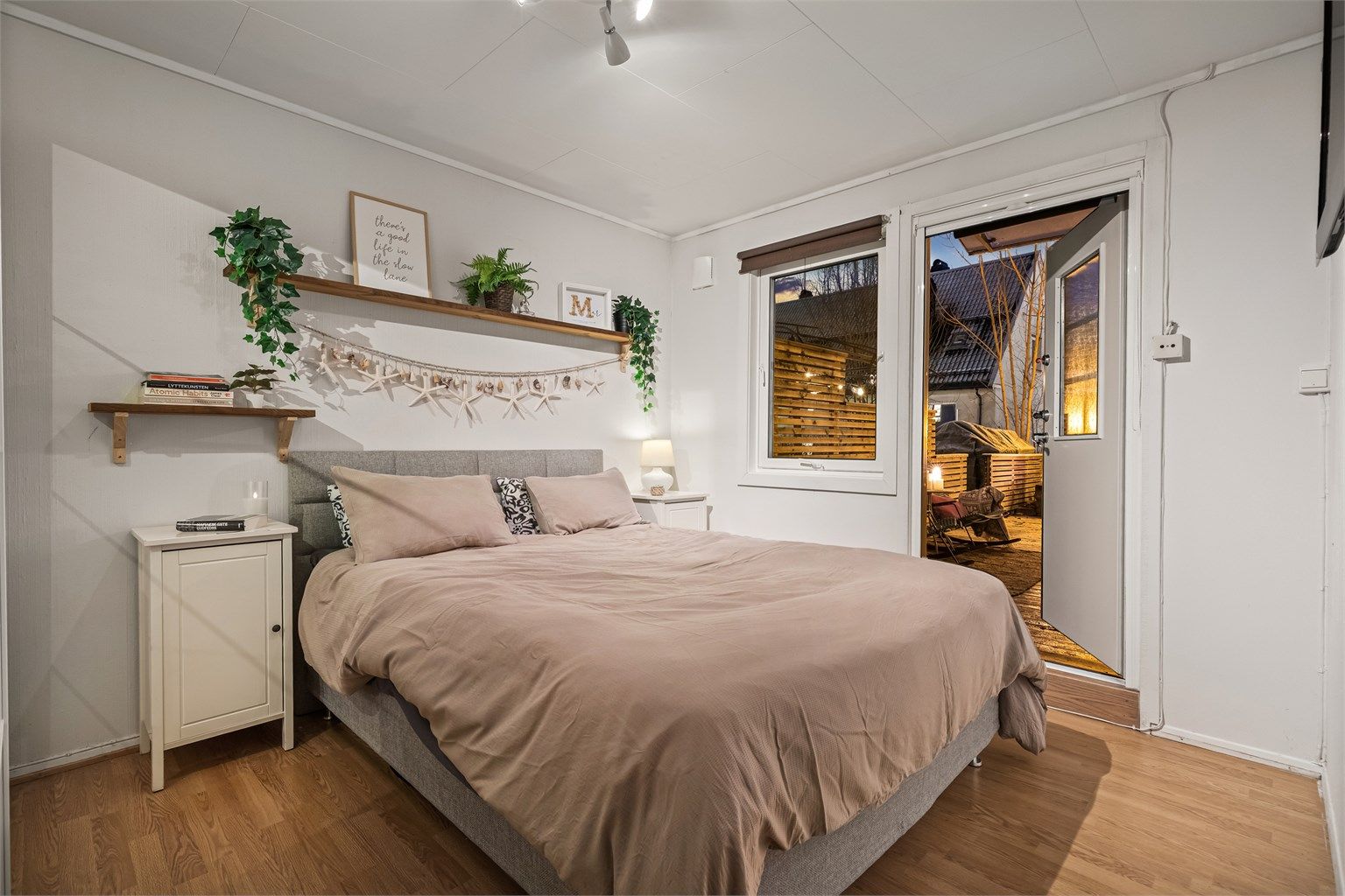 Romslig hovedsoverom med direkte utgang til en stor terrasseplatting - perfekt for å nyte morgenkaffen i fred og ro.