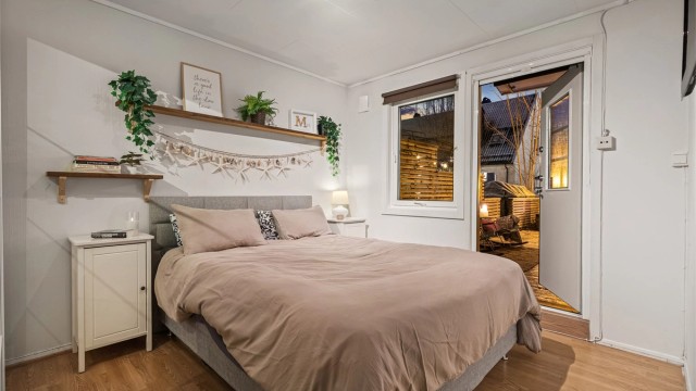 Romslig hovedsoverom med direkte utgang til en stor terrasseplatting - perfekt for å nyte morgenkaffen i fred og ro.