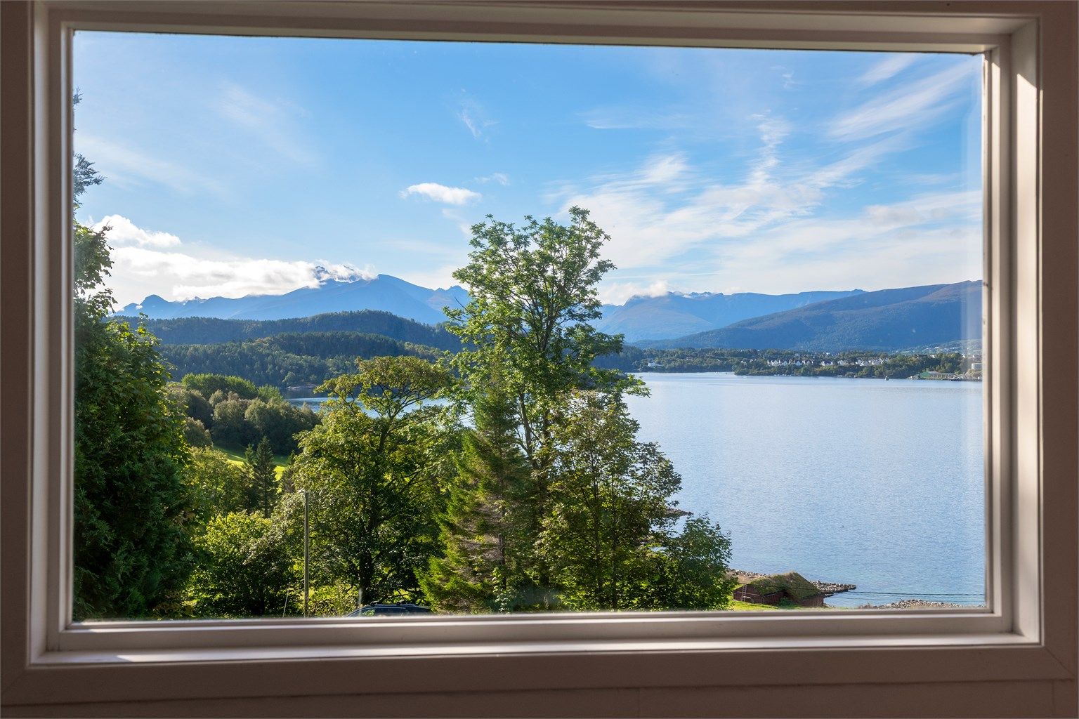 Utsikt fra stuevinduet over Ellingsøyfjorden mot fjellene på sørsiden.