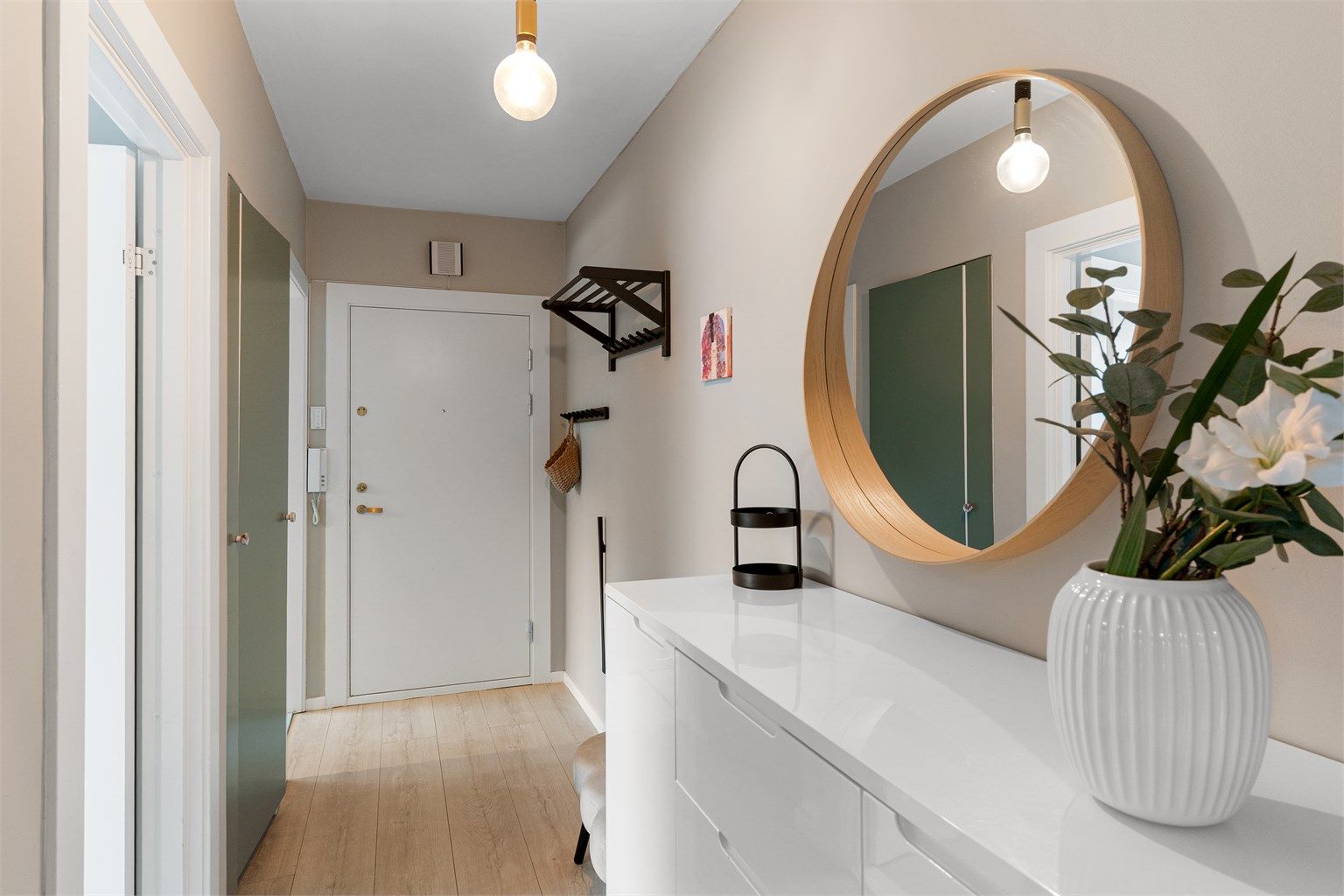 Entréen fungerer som leilighetens bindeledd, med nymalte vegger fra 2023.