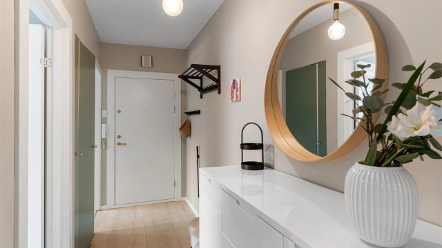 Entréen fungerer som leilighetens bindeledd, med nymalte vegger fra 2023.