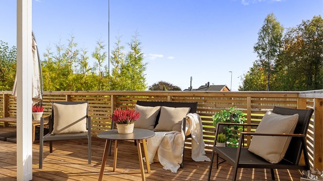 Uteplassen har dekke av terrassebord og rekkverk i tre.