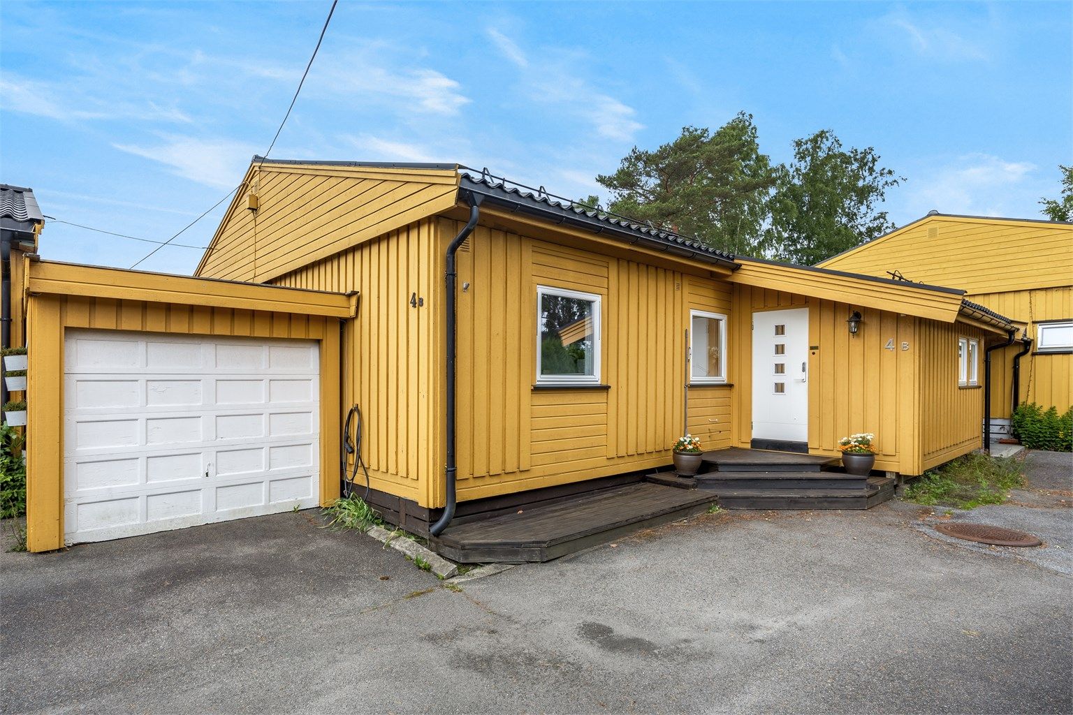 Fasade og garasje med elbil-lader montert. (TG 3 er satt på garasjetaket samt ytterkledning. Det foreligger ikke midlertidlg brukstillatelse/ferdigattset på utvidelse av entré/soverom 3 og garasje)