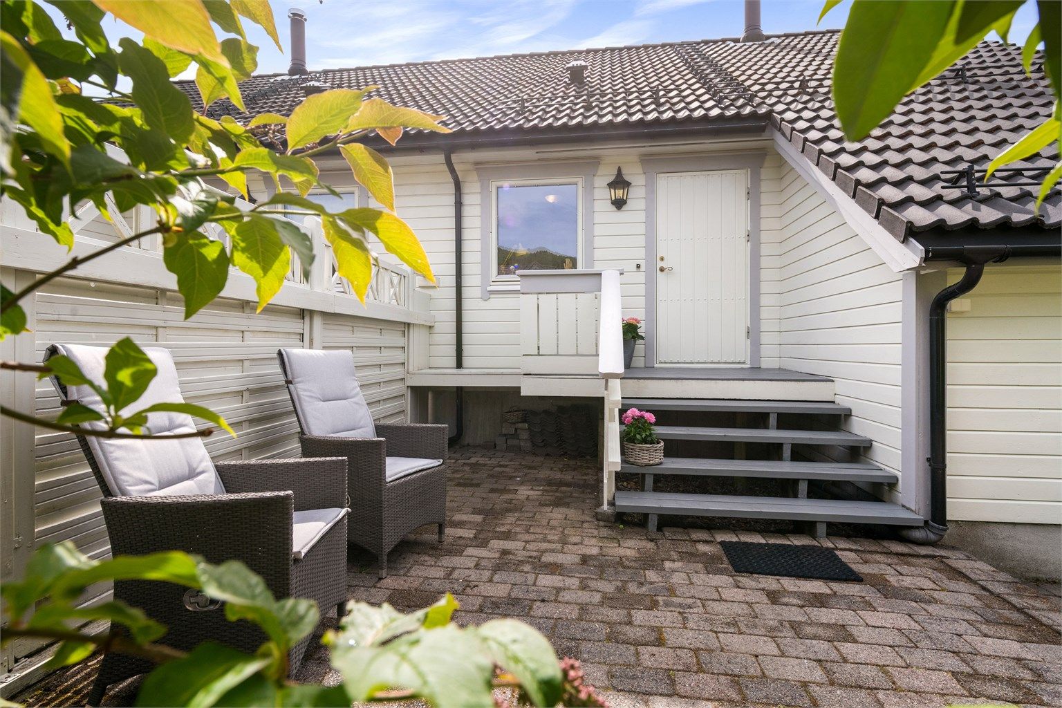 Ved inngangspartiet er det en lun og skjermet uteplass med belegningsstein.