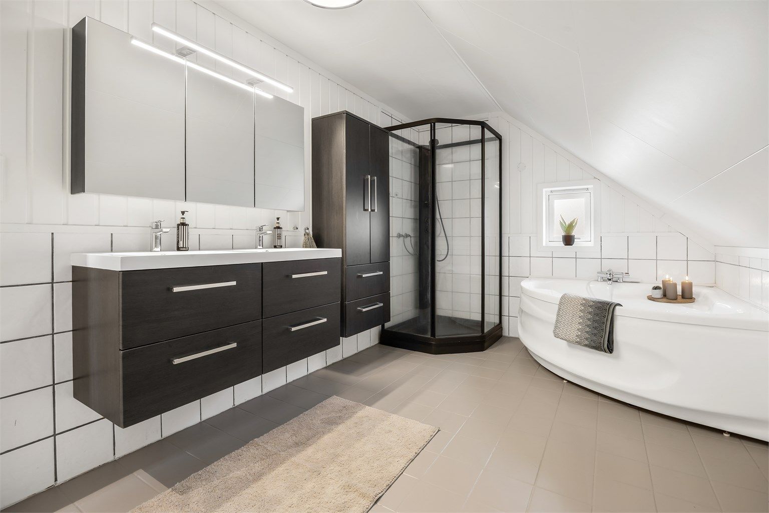 Det romslige badet i andre etasje har både badekar og dusjkabinett, samt gulvvarme.