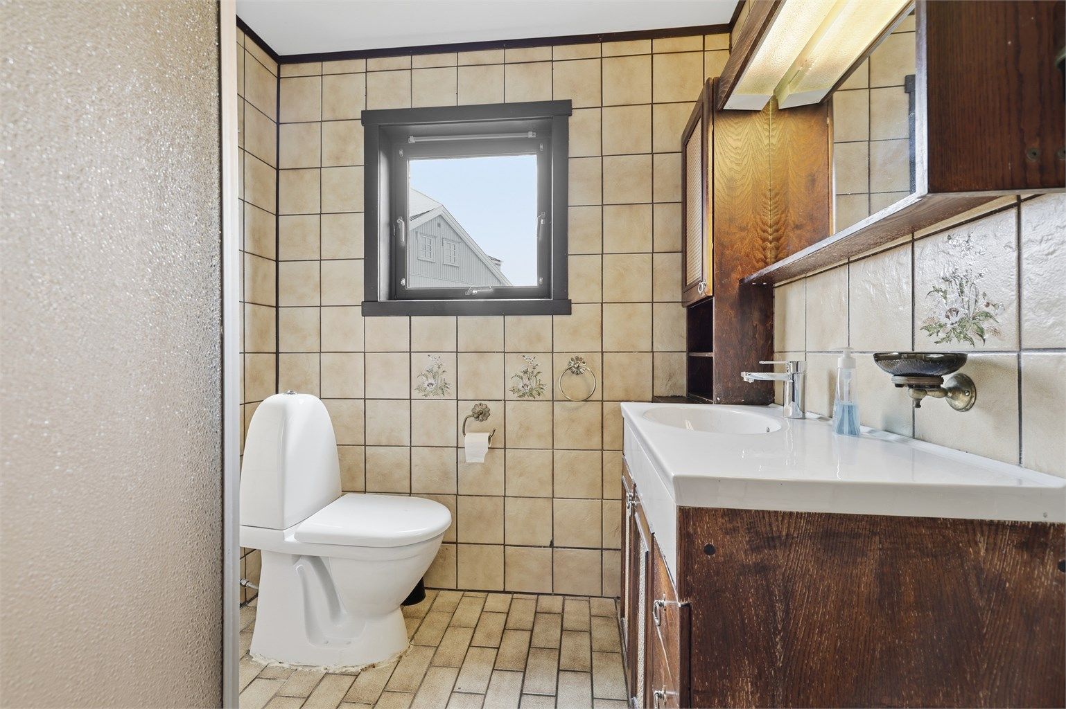 Bad i første etasje med fliser på gulv og vegger