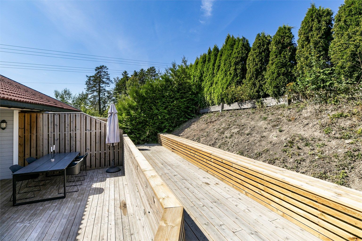 Et høyere nivå over terrassen er anlagt helt nylig, med langstrakt sittebenk. Beplantning kan gi nytt liv til den solfylte skrenten ovenfor.