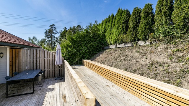 Et høyere nivå over terrassen er anlagt helt nylig, med langstrakt sittebenk. Beplantning kan gi nytt liv til den solfylte skrenten ovenfor.