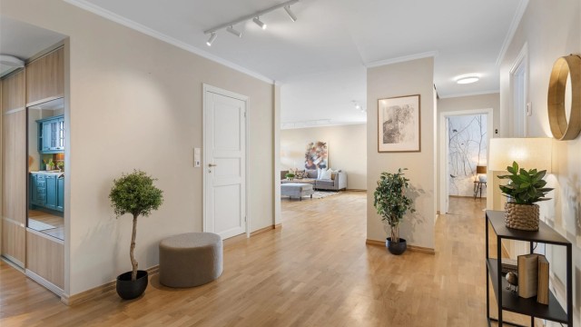 Romslig hall/gang med skyvedørsbarderobe.