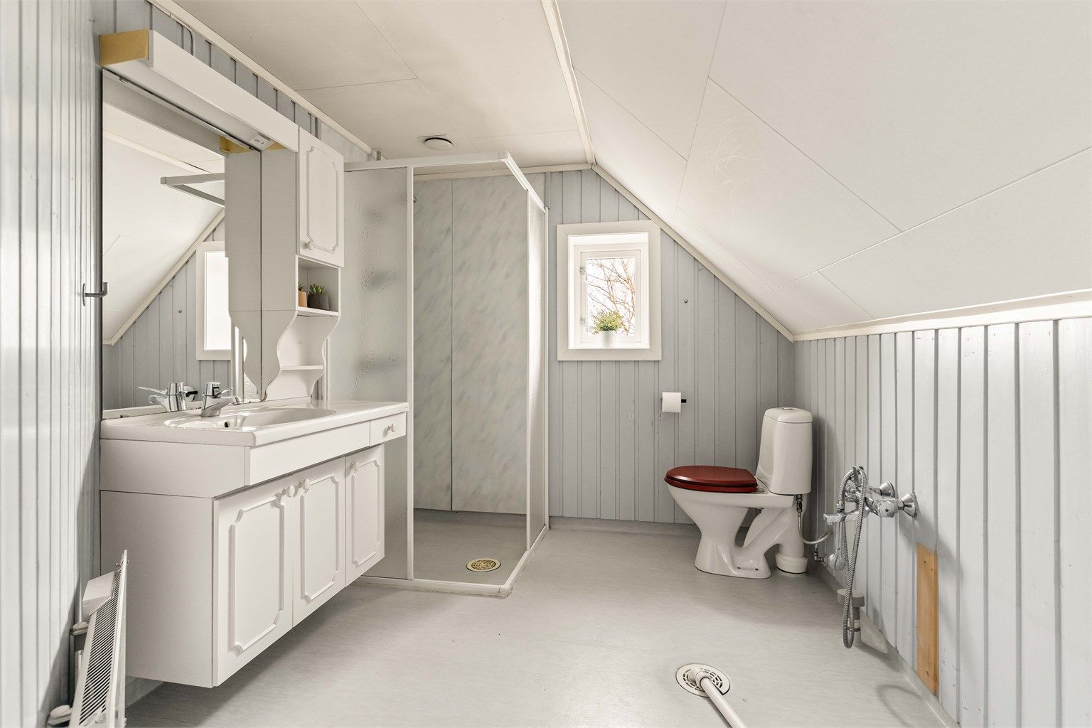 Boligens baderom befinner seg i 2. etg. og inneholder servantinnredning, dusjhjørne, toalett og opplegg for vaskemaskin.