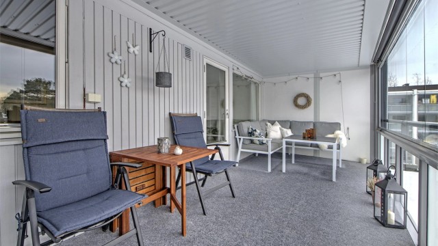 Innglassingen av balkongen fungerer som en "ekstra" stue fra vår til høst - innglassingen kan enkelt åpnes opp