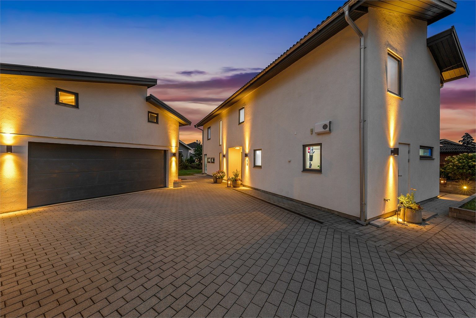 Gårdsrommet binder huset sammen med en stor garasje oppført i samme stil