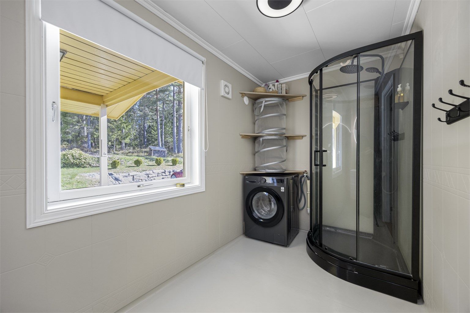Badet er utstyrt med dusjkabinett og har opplegg for vaskemaskin.