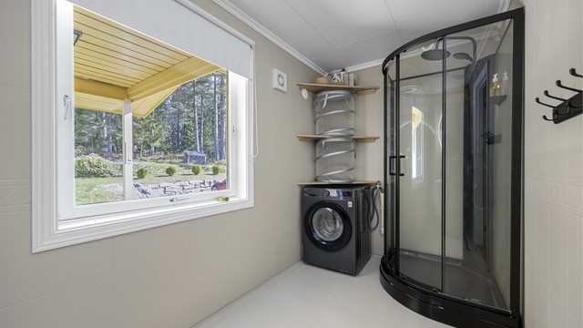Badet er utstyrt med dusjkabinett og har opplegg for vaskemaskin.
