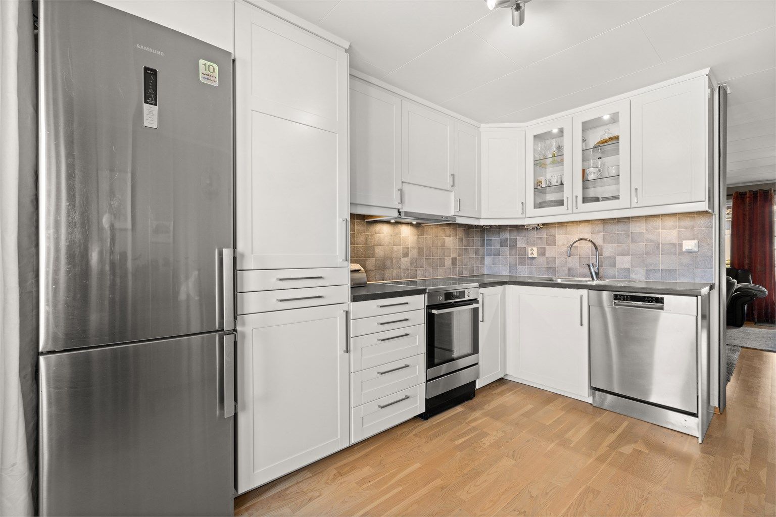 Kjøkkeninnredningen har hvite fronter og bra med skapplass. Mekanisk kjøkkenventilator tilkoblet avtrekkskanal.