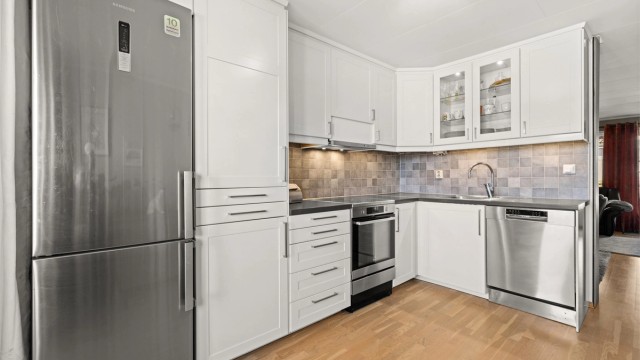 Kjøkkeninnredningen har hvite fronter og bra med skapplass. Mekanisk kjøkkenventilator tilkoblet avtrekkskanal.