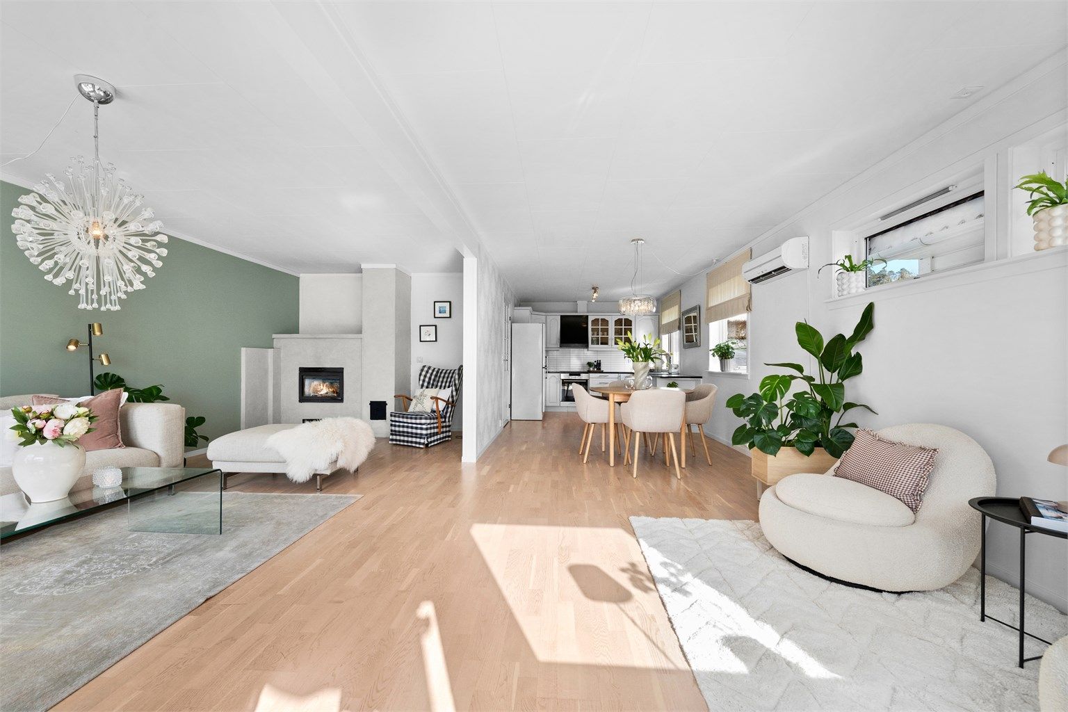 Gjennomgående gulv og lyse veggflater binder de ulike sonene i første etasje elegant sammen