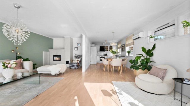 Gjennomgående gulv og lyse veggflater binder de ulike sonene i første etasje elegant sammen