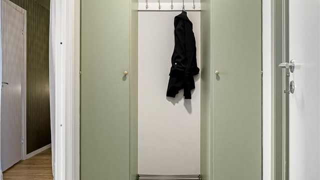Garderobeskap på hver side med knaggoppheng imellom.