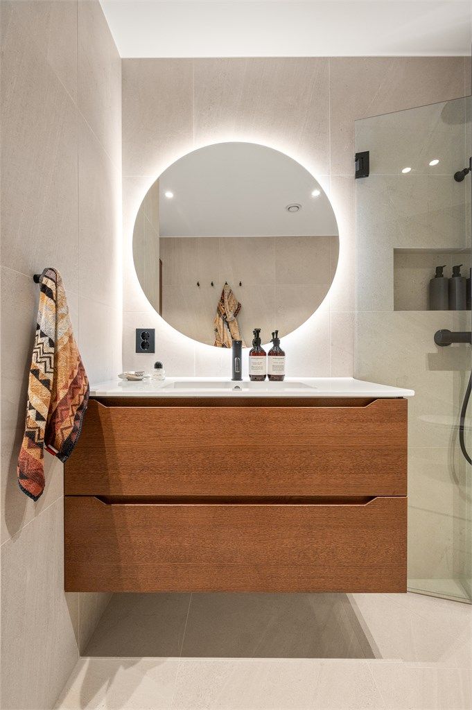 Innredningen fra Linnbad har en servant nedfelt i skuffeseksjon og et elegant, bakbelyst speil.